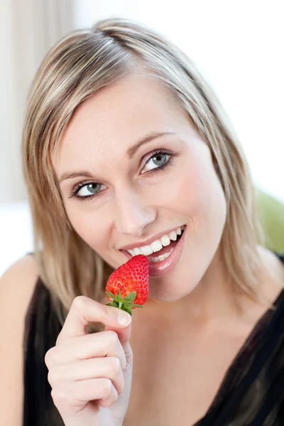 Lächelnde Frau isst eine Erdbeere — Stockfoto