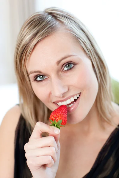 Сияющая женщина ест клубнику — стоковое фото