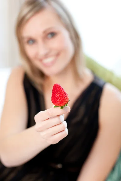 Mulher alegre comendo um morango — Fotografia de Stock
