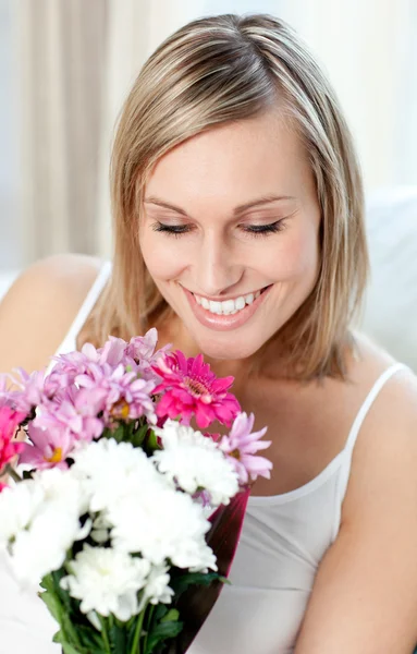 Retrato de uma mulher alegre segurando um monte de flores — Fotografia de Stock