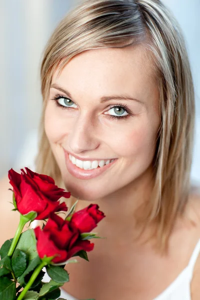 Retrato de una mujer sonriente sosteniendo rosas — Foto de Stock