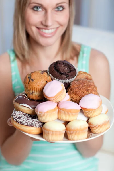 Usmívající se žena drží talíř koláčů — Stock fotografie