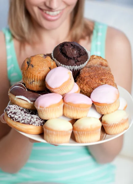 Blondýnka drží talíř koláčů — Stock fotografie