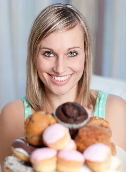 Bright woman holding a plate of cakes — Stock Photo, Image