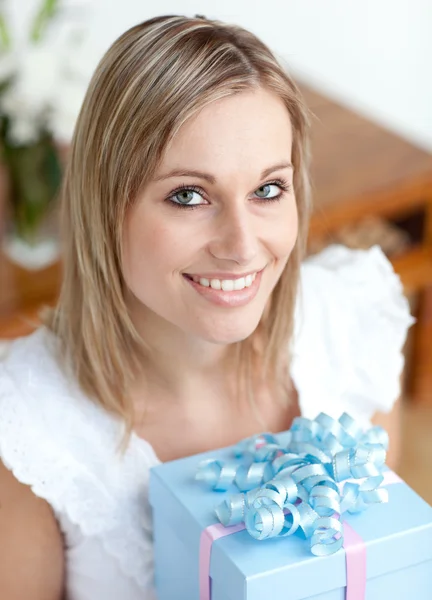 Весела молода жінка тримає подарунок сидить на підлозі — стокове фото