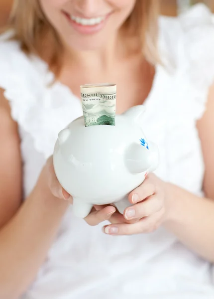 Mujer rubia ahorrando dinero en una alcancía —  Fotos de Stock