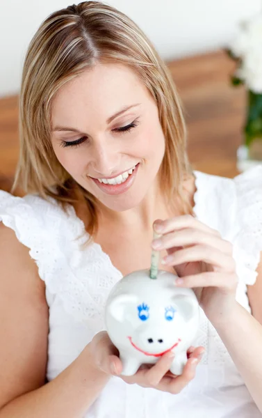 Mooie vrouw geld te besparen in een piggy-bank — Stockfoto