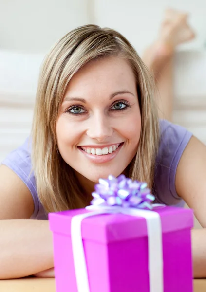 Веселая женщина смотрит на подарок — стоковое фото