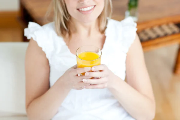 Donna sorridente che beve un succo d'arancia — Foto Stock