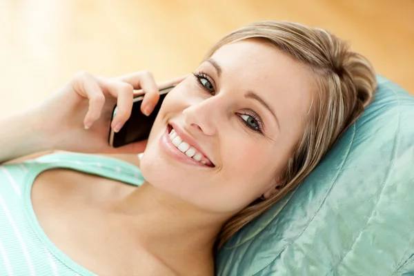 Ευτυχισμένη κοπέλα μιλάει στο τηλέφωνο που βρίσκεται σε έναν καναπέ — Φωτογραφία Αρχείου