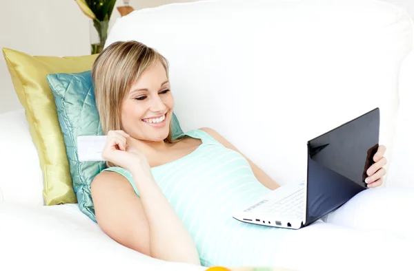 Jolie femme faisant du shopping en ligne allongé sur un canapé — Photo