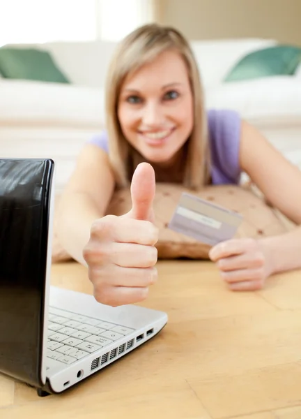 Fröhliche blonde Frau beim Online-Shopping auf dem Boden liegend — Stockfoto