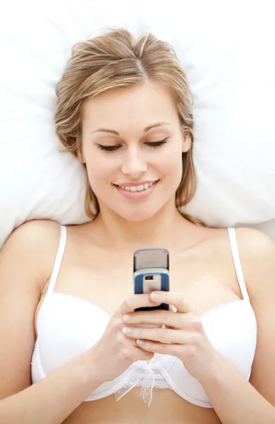 Lächelnde Frau in Unterwäsche sendet einen Text — Stockfoto