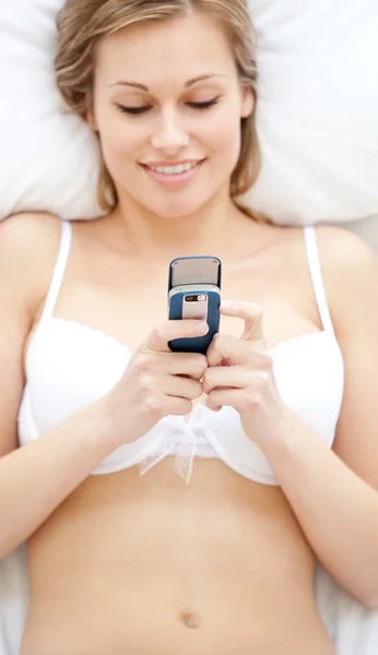 Positive Frau in Unterwäsche sendet einen Text — Stockfoto