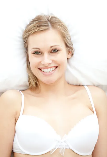 Lachende vrouw in ondergoed liggend op bed — Stockfoto