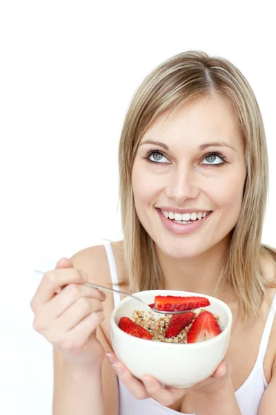 Усміхнена жінка їсть зернові з полуницею — стокове фото