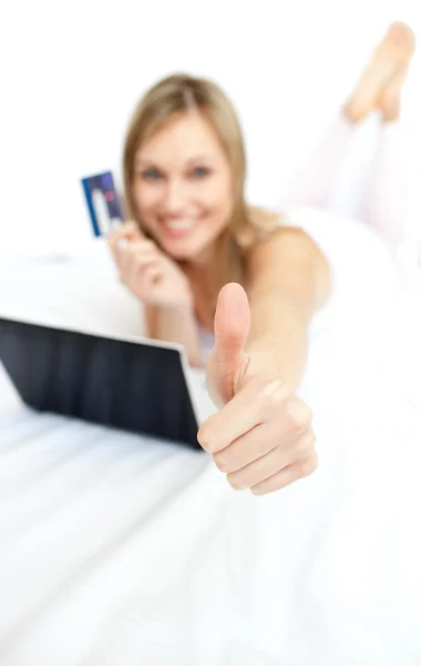 Glad kvinna med en tumme upp shopping online — Stockfoto