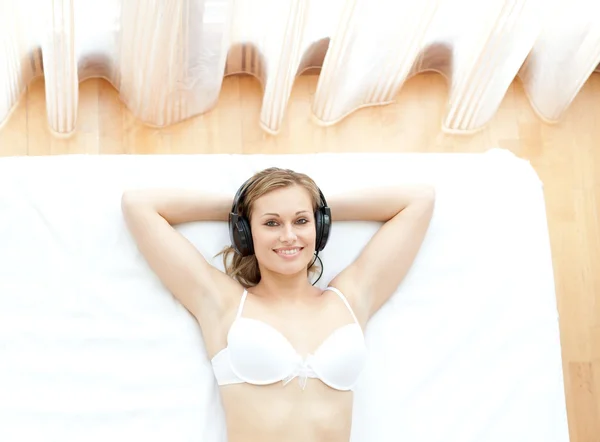 Ontspannen vrouw in ondergoed luisteren muziek — Stockfoto