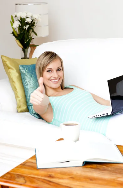 Mulher alegre surfar na internet deitado em um sofá — Fotografia de Stock