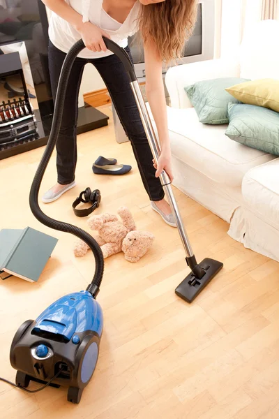 거실을 진공 청소기로 청소 하는 젊은 여자 — 스톡 사진