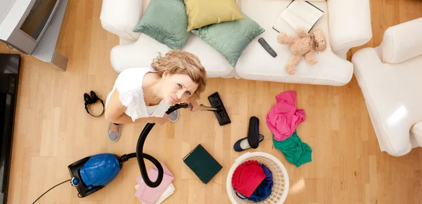 Moe vrouw stofzuigen de living-room — Stockfoto