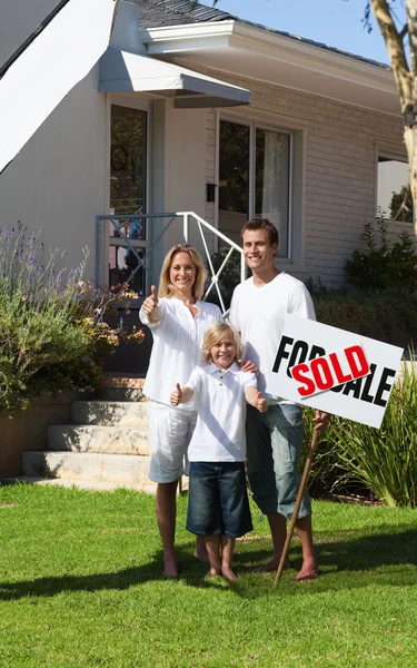 Happy family with their new home in the garden — Stock Photo, Image