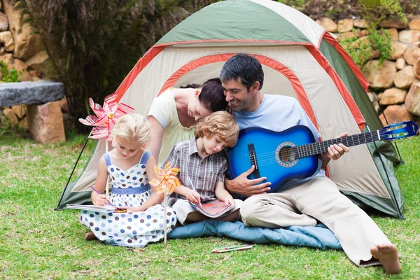 A szülők és gyermekek gitározni egy sátorban — Stock Fotó