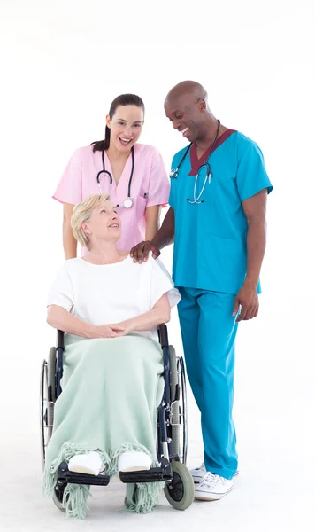 Enfermeira e médico cuidando de um paciente em uma cadeira de rodas — Fotografia de Stock