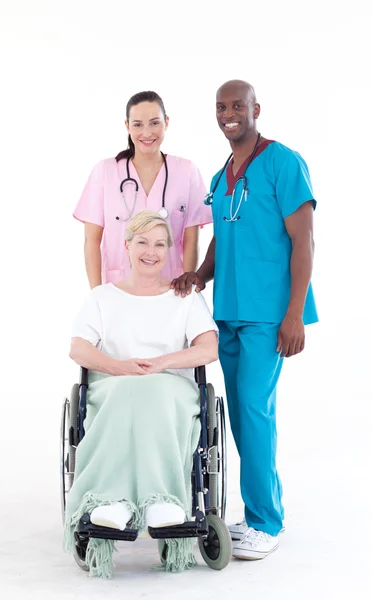 Doctors with a patient in a wheel chair — Stock Photo, Image