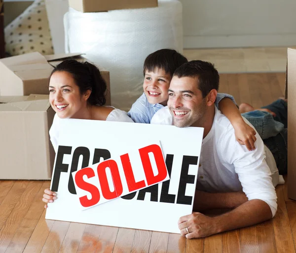Sonriente familia en el suelo después de comprar casa — Foto de Stock