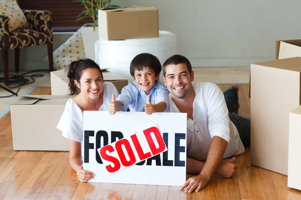 Familia feliz tendida en el suelo después de comprar casa — Foto de Stock