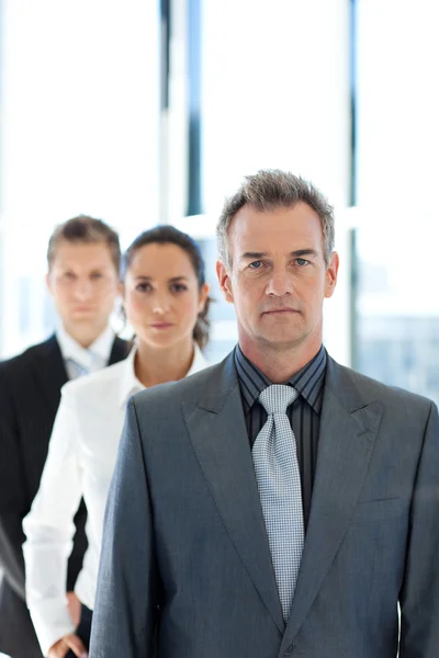 Empresario liderando un equipo de negocios en una fila — Foto de Stock