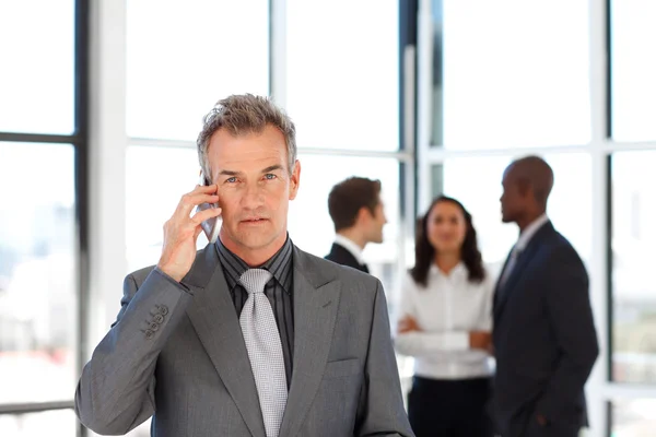 Volwassen zakenman op telefoon kijken naar de camera — Stockfoto