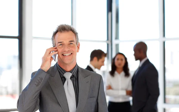 Volwassen zakenman op telefoon in office — Stockfoto