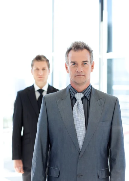 Senior and young businessmen looking to the camera — Stock Photo, Image