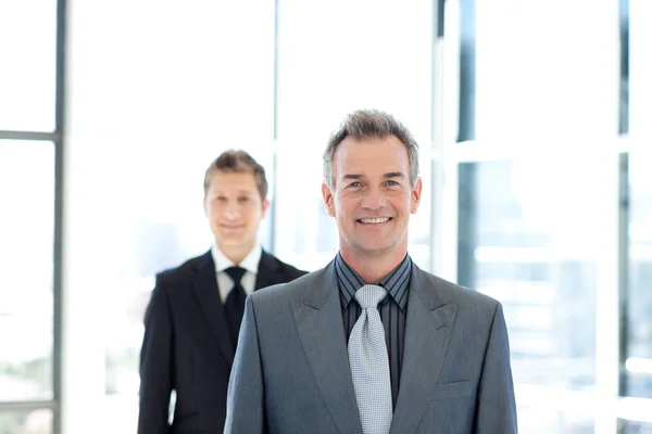Smiling businessman standing in front of the camera — Stock Photo, Image