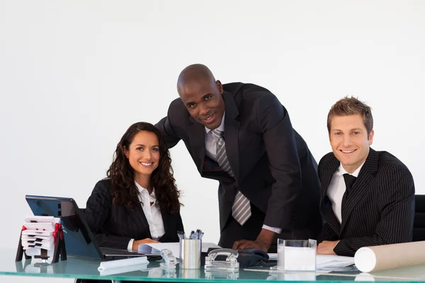 Business team in un ufficio sorridente alla telecamera — Foto Stock