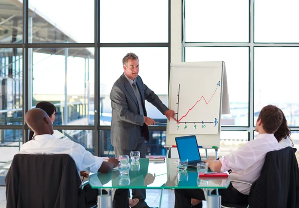 Senior businessman reporting to graphs in a presentation — Stock Photo, Image