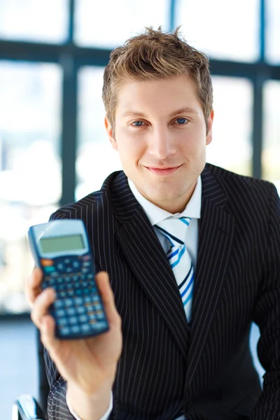 Jeune homme d'affaires tenant une calculatrice — Photo