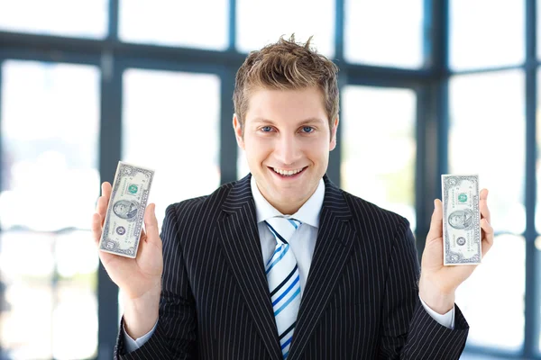 Empresário sorridente segurando dólares — Fotografia de Stock