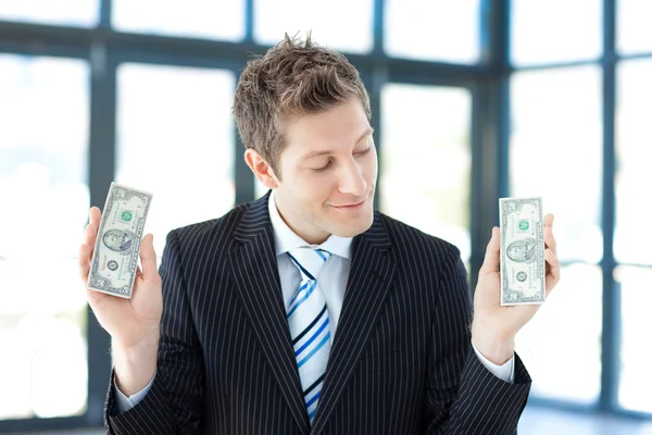 Un hombre de negocios sonriente sosteniendo dinero — Foto de Stock