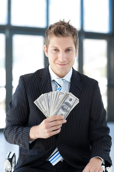 Привлекательный молодой бизнесмен показывает доллары — стоковое фото