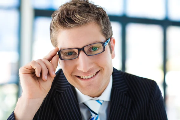 Бизнесмен смотрит в камеру в очках — стоковое фото