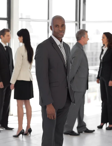 Business leader looking at camera in front of team — Stock Photo, Image