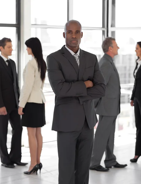 Hombre de negocios mirando a la cámara con el grupo en segundo plano — Foto de Stock