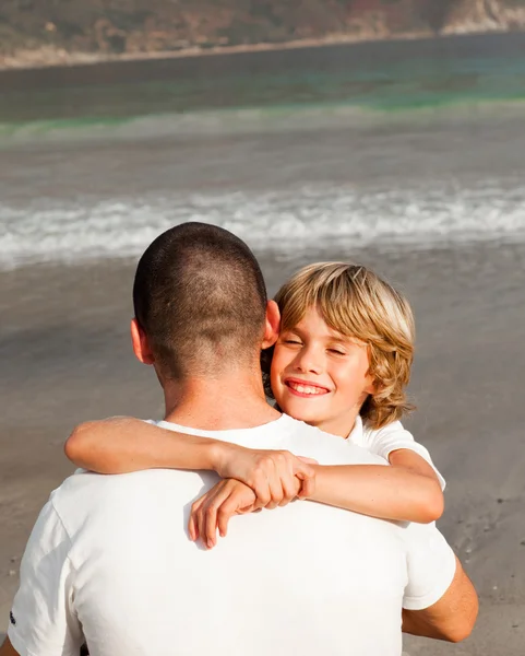 Zoon en vader knuffelen op het strand — Stockfoto