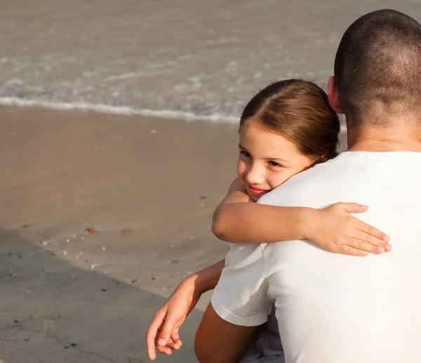 Dotter och hennes pappa kramar på stranden — Stockfoto