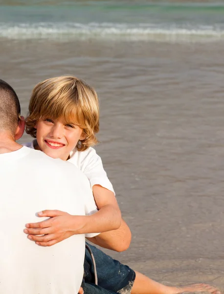 Сын и отец обнимаются на пляже — стоковое фото