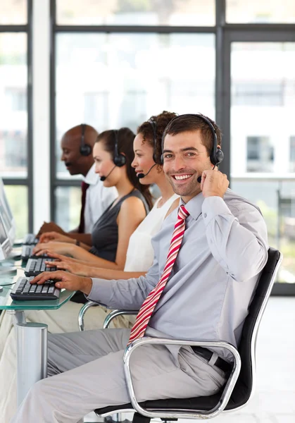 Jungunternehmer im Callcenter lächelt in die Kamera — Stockfoto