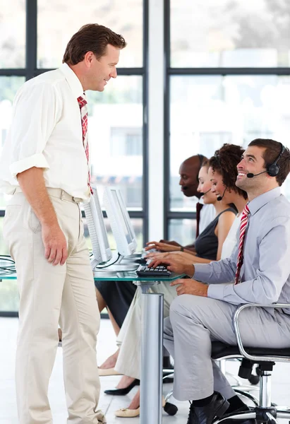 Gerente sênior conversando com um trabalhador em um call center — Fotografia de Stock